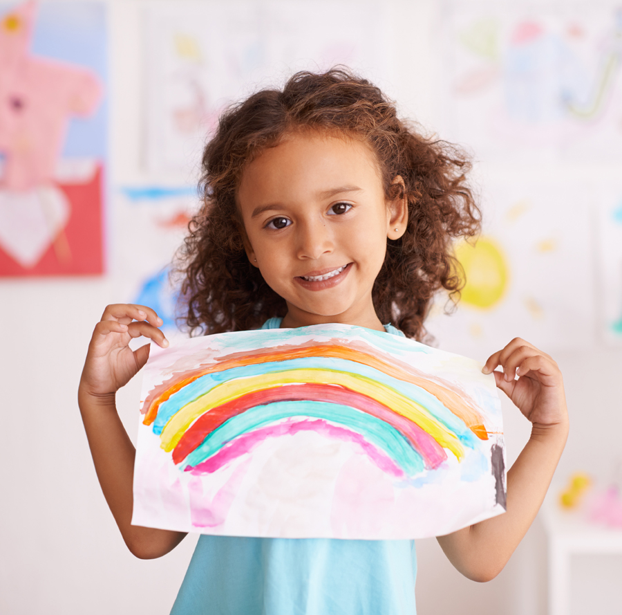 Girl holding up a piece of paper with a rainbox