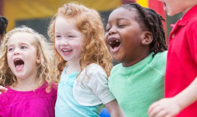 Group of five diverse children playing outdoors