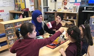 Teacher and students setting up project in class