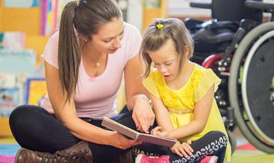 Teacher and student reading a book