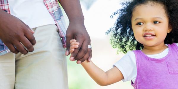 Young girl holding an adult's hand