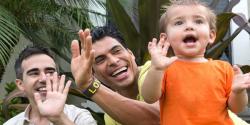 two parents with a young child clapping their hands