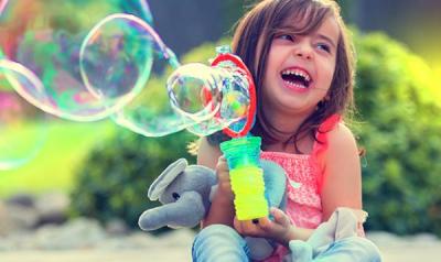 Young girl playing with a bubble machine