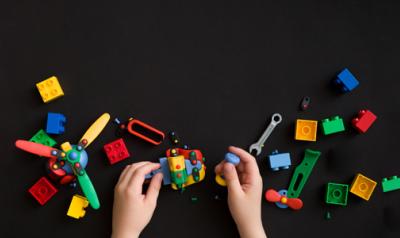 a child's hands playing with assorted toys