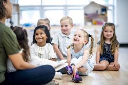 children listening to a teacher talking