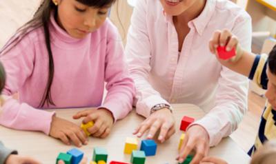 Children and teacher playing with blocks