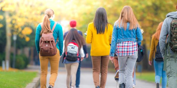 Back view of college students walking on campus