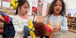 two children playing with a puppet