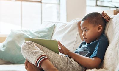 young boy learning on an ipad