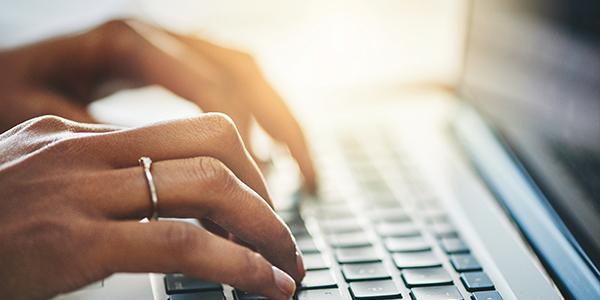 fingers typing on a laptop