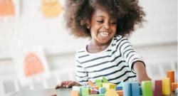 A happy child playing with blocks.