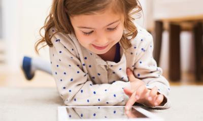 A young child draws on a tablet