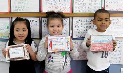 Three students holding their math mini-books