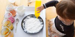 A child pouring ingredients into a bowl.