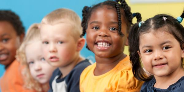 Five diverse children smiling at camera