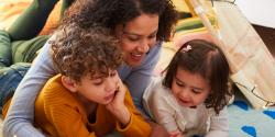 Mother and two children reading on the floor