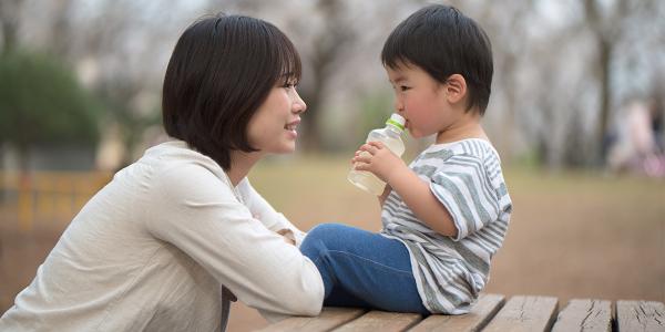 Mother and son outside talking on a picnic table.