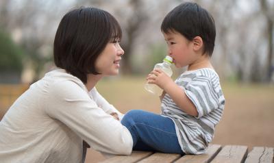 Mother and son outside talking on a picnic table.