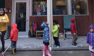 Children standing outside in rain