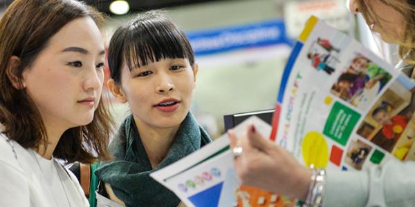 people looking at a catalog together at an event