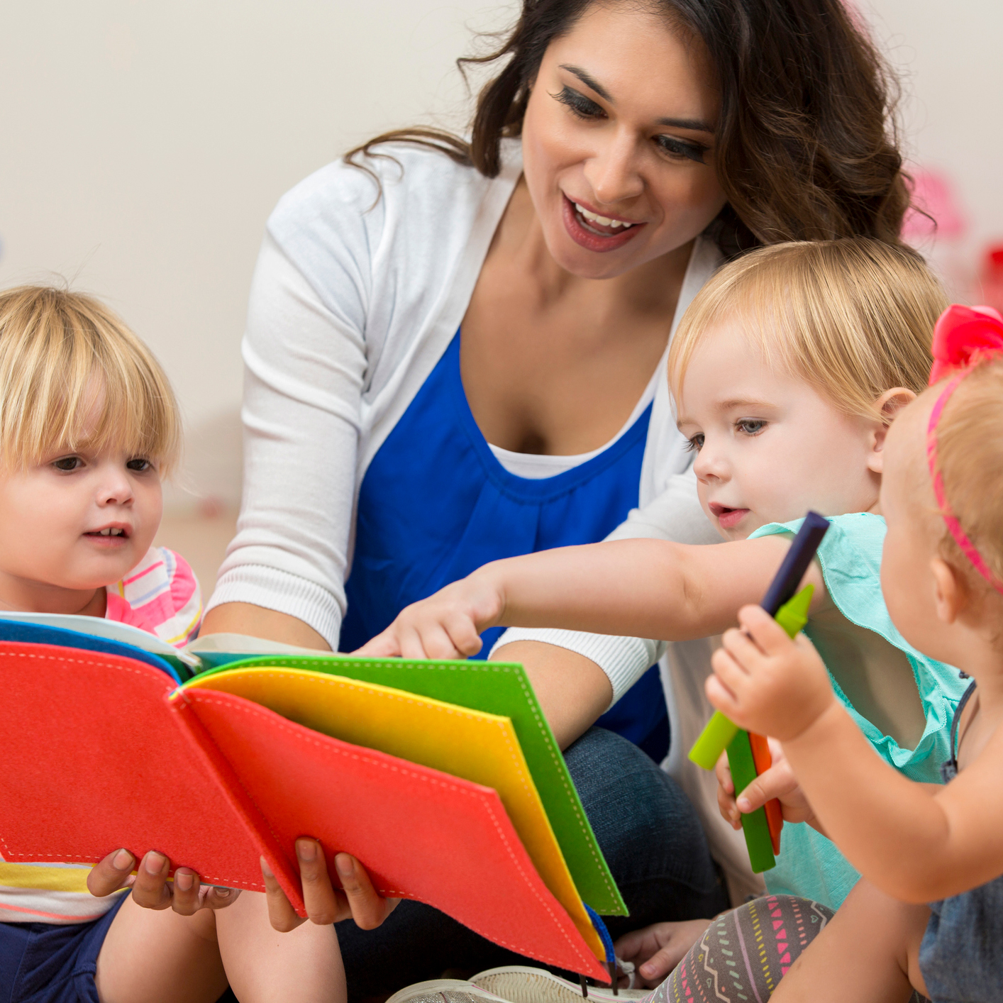 Teacher reading to a group of young children.