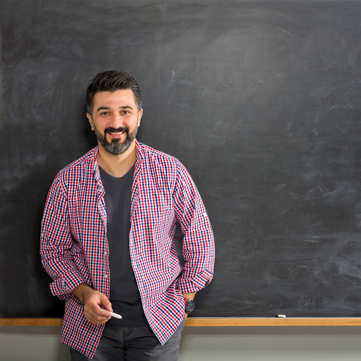 Man with chalk standing in front of chalkboard