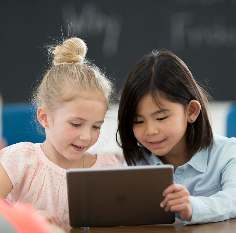 Two kindergarteners working on a tablet device