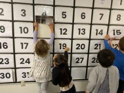 children playing with a big calendar