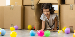 a child crawling under a cardboard fort