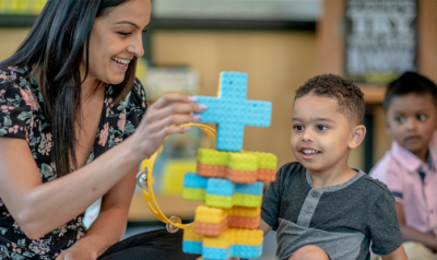 a child and teacher playing with blocks