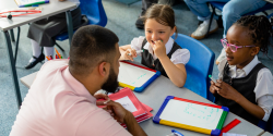 a teacher with some students drawing on dry erase boards