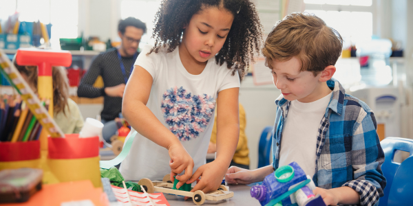 Two primary grade children tinkering and engineering with loose parts