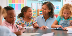 a teacher talking with students in a classroom