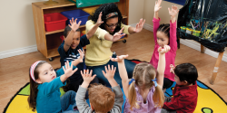 a group of students and a teacher raising their hands together