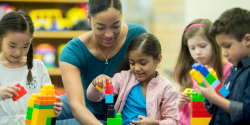 a teacher observing children playing blocks