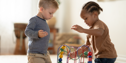 two children playing with an interactive bead toy together