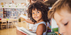 a child smiling while reading a book