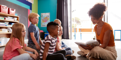 a teacher reading a book to children