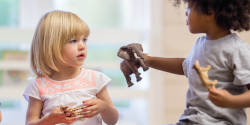 a children showing a peer an elephant doll