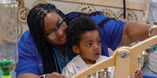 feature teacher beulah wiggins exploring a simple machine craft with a child