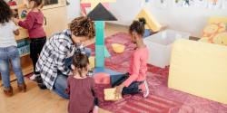 A teacher and students building with blocks.